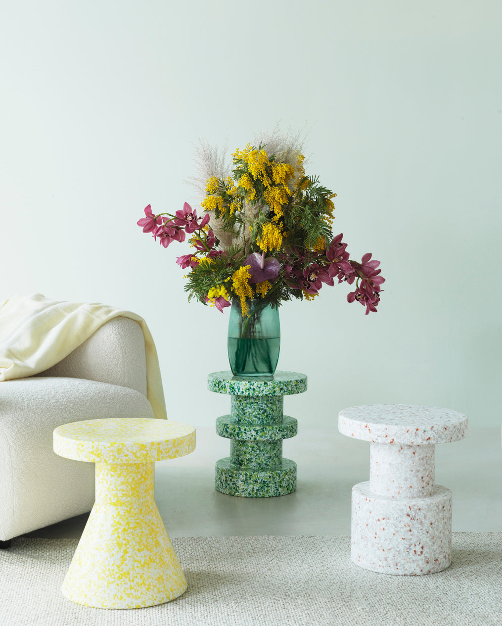 Three Bit Stools in White Multicolor, made of recycled material by Normann Copenhagen, in different styles with flowers in a vase.