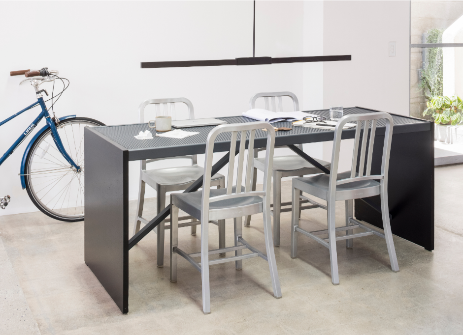 A sustainable table with four recycled metal Navy Chairs by Emeco.