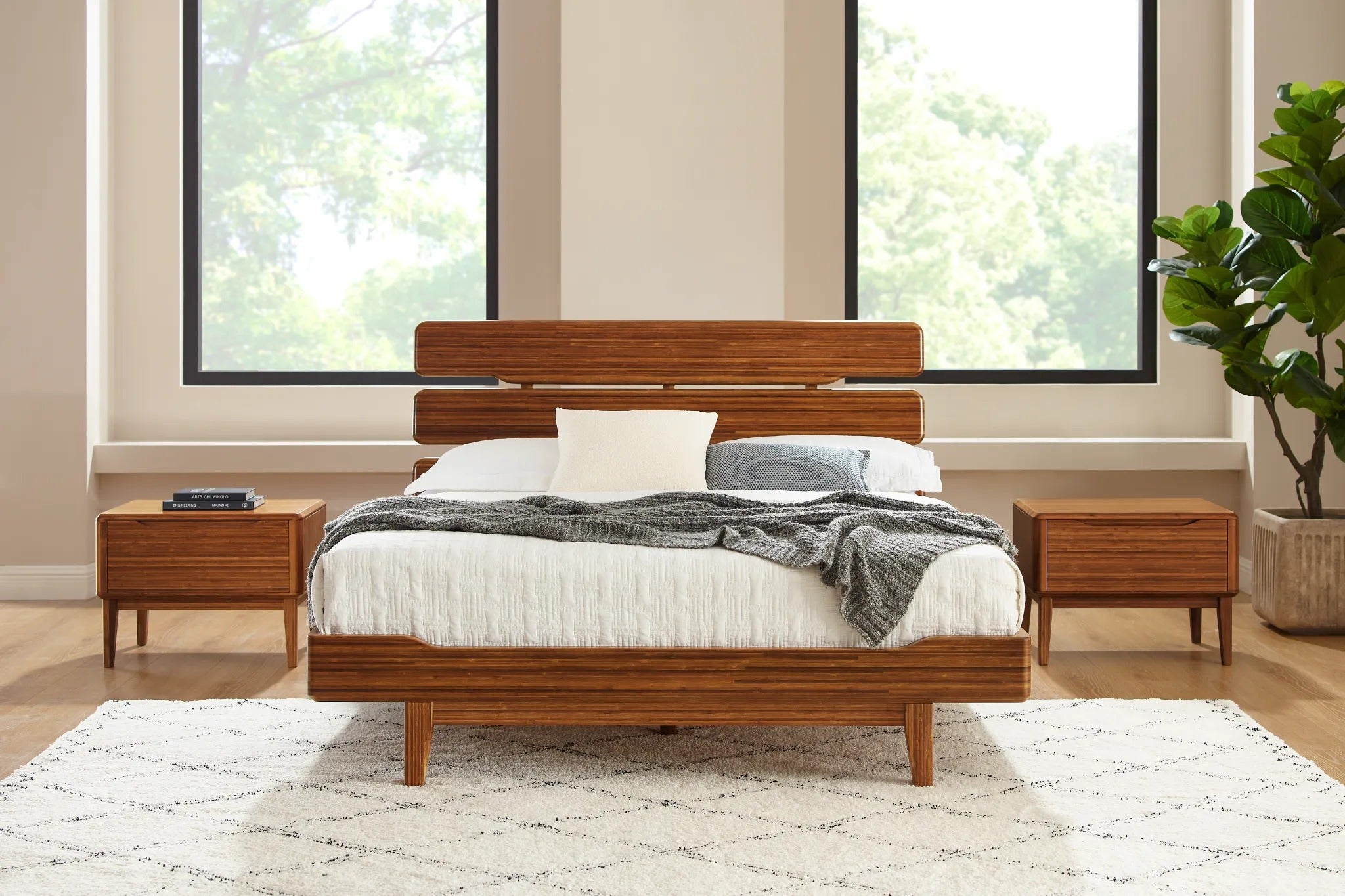 A renewable Currant Bamboo Bedframe by Greenington, in amber color, placed in a bedroom with two side drawers.