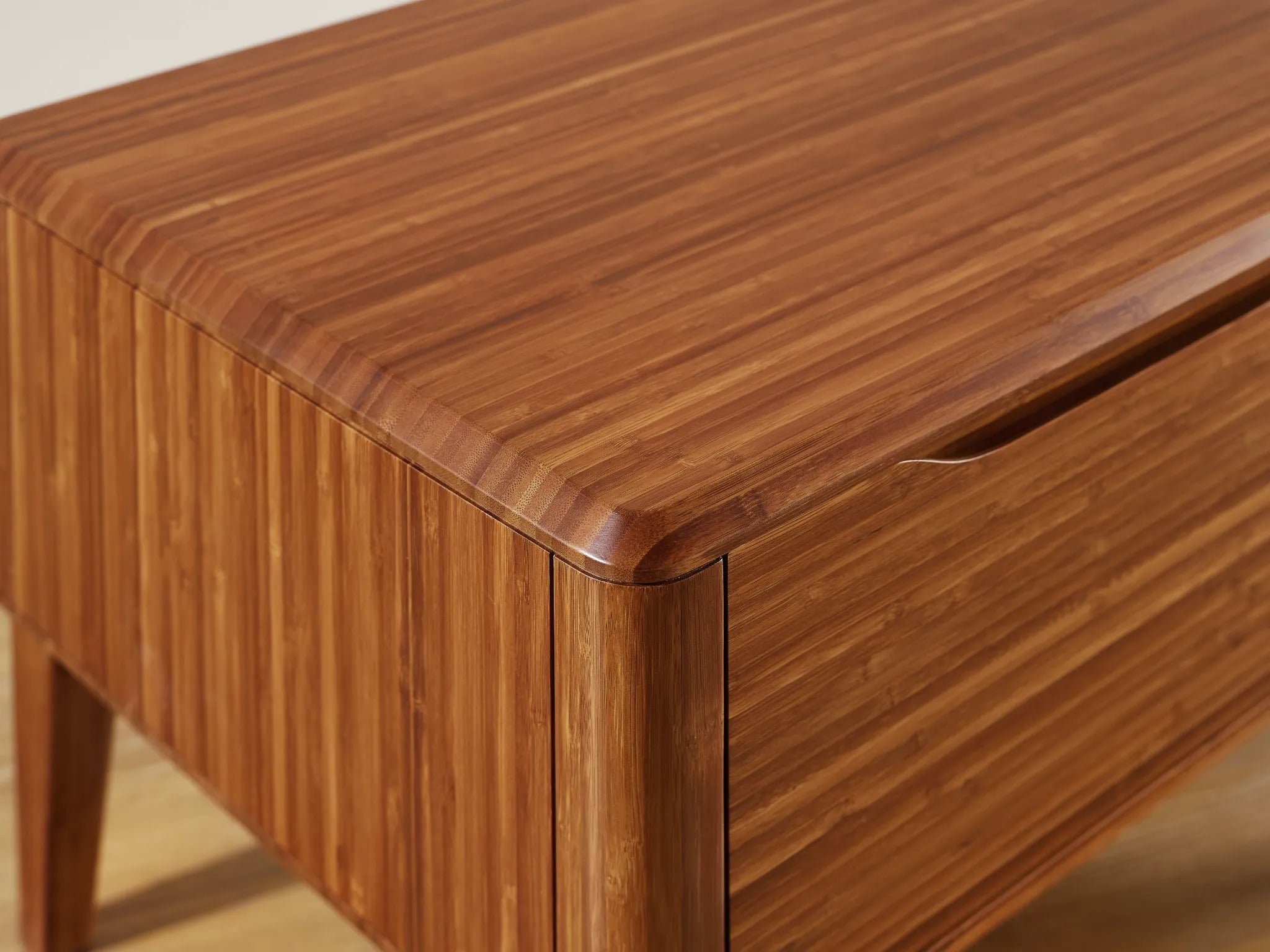 A close-up detail view of the renewable Currant Bamboo Nightstand by Greenington, in amber color.