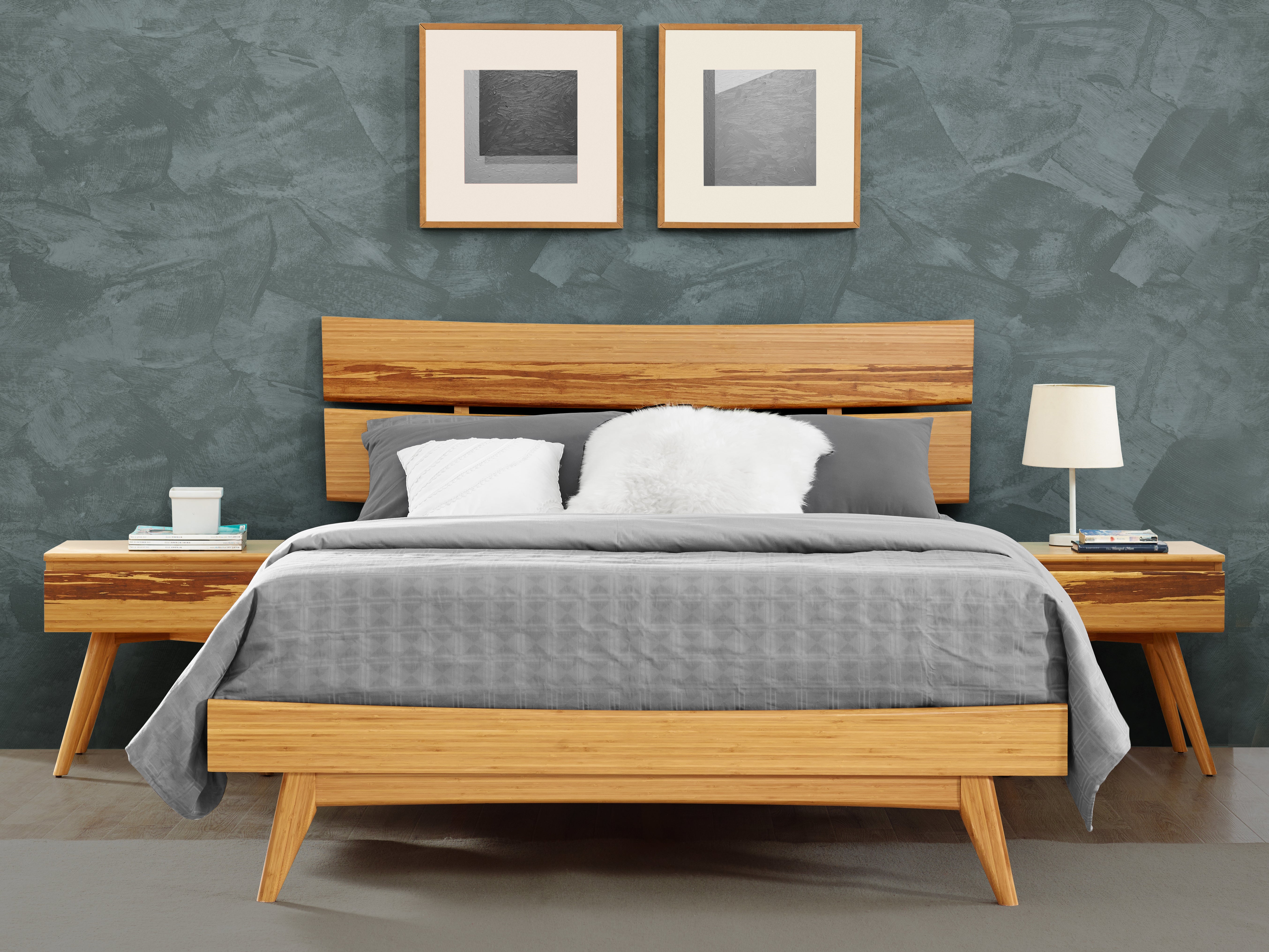 A renewable Azara Bamboo Nightstand by Greenington, in caramel color, placed next to the bed in a bedroom.