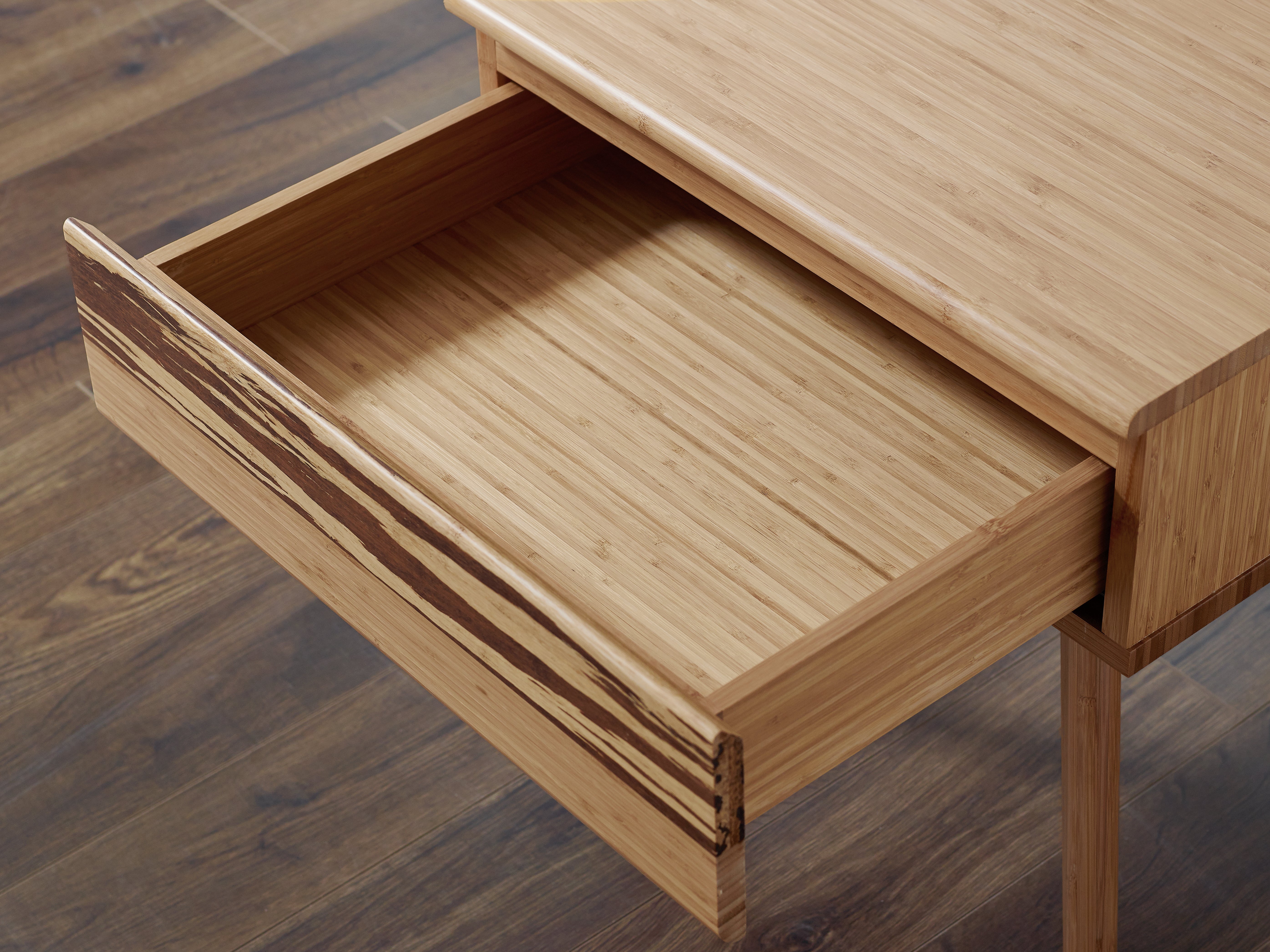 The detail of the drawer of a renewable Azara Bamboo Nightstand by Greenington, in caramel color.