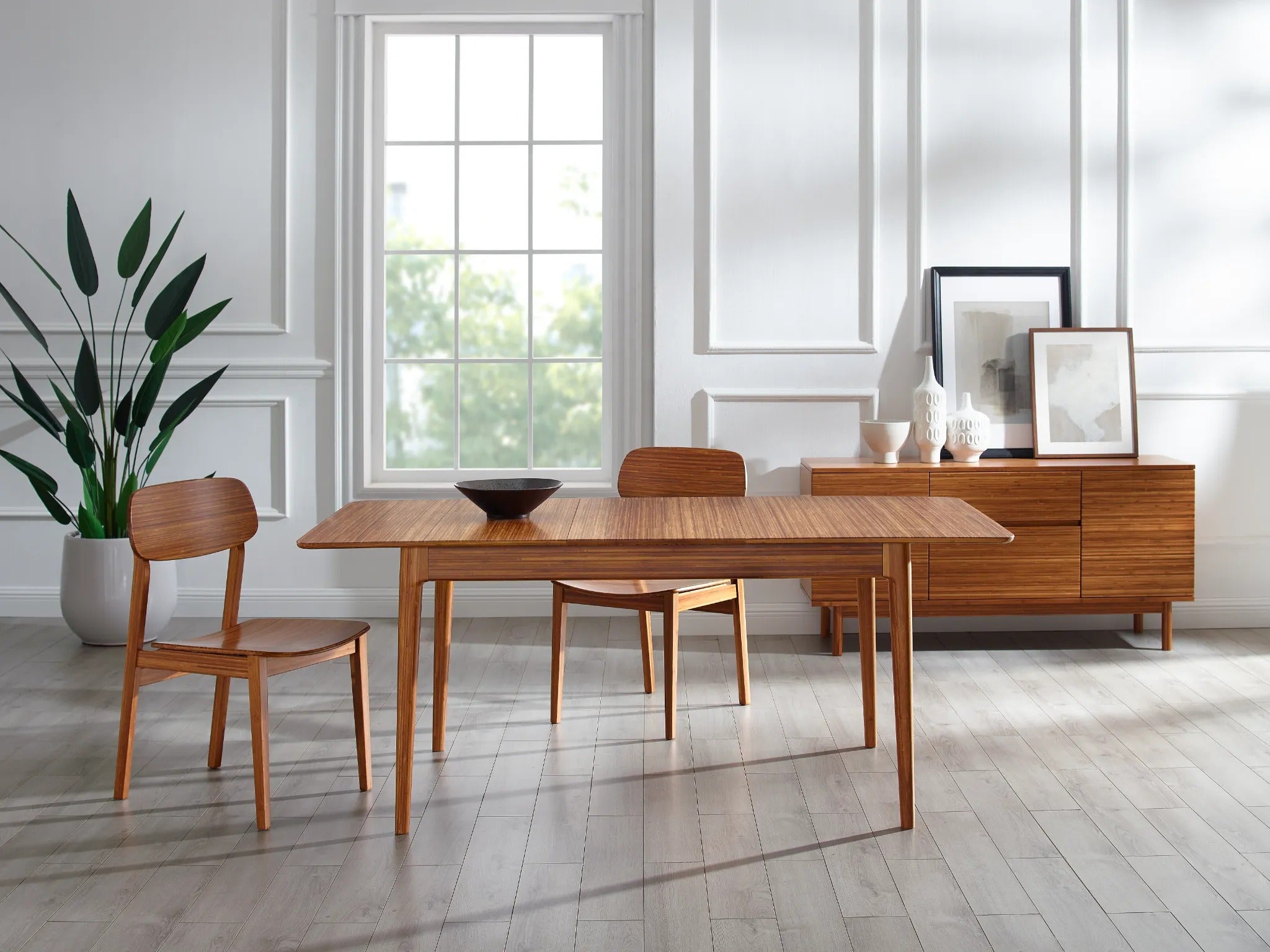 A renewable Linden Gateleg Dropleaf Dining Table by Greenington, placed in a living room together with two eco-friendly chairs.