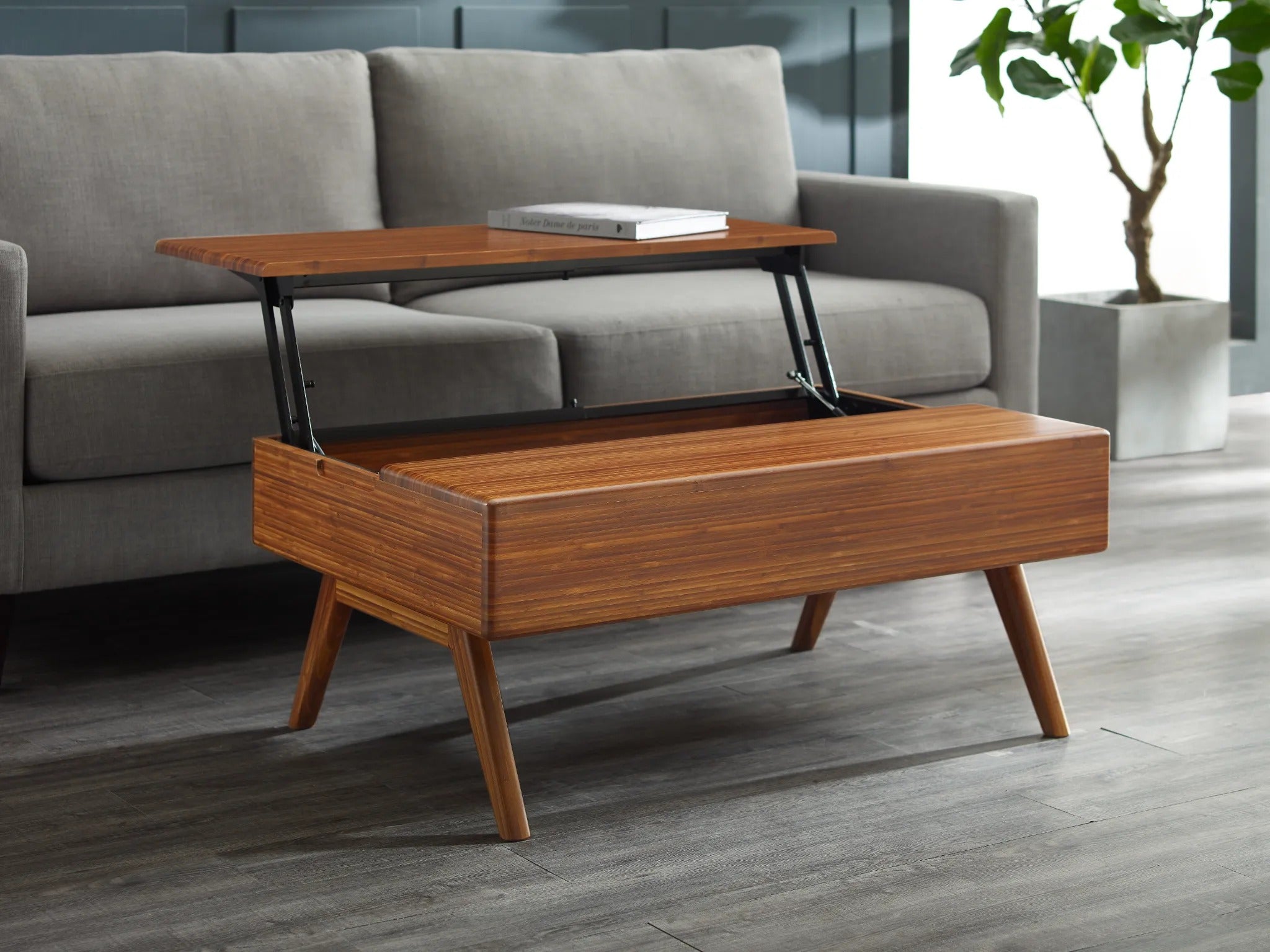 A Rhody Lift Coffee Table with Storage by Greenington, shown with top lifted, in a living minimalist room with a grey couch.