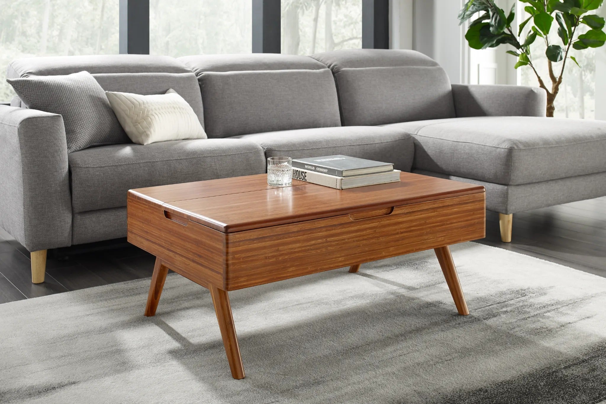 A sustainable Rhody Lift Coffee Table with Storage by Greenington, placed by a dining table together with a soft couch.