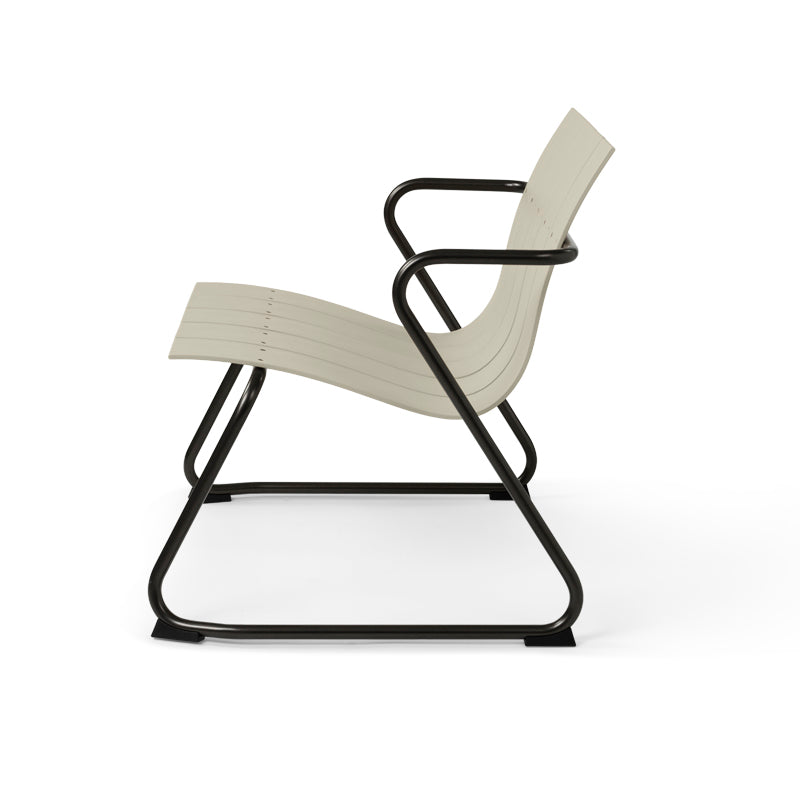 An Ocean Lounge Chair made of recycled materials by Mater, in sand color, side view.