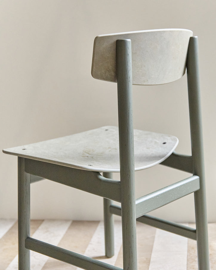 A green Conscious chair made with recycled material by Mater, back view.