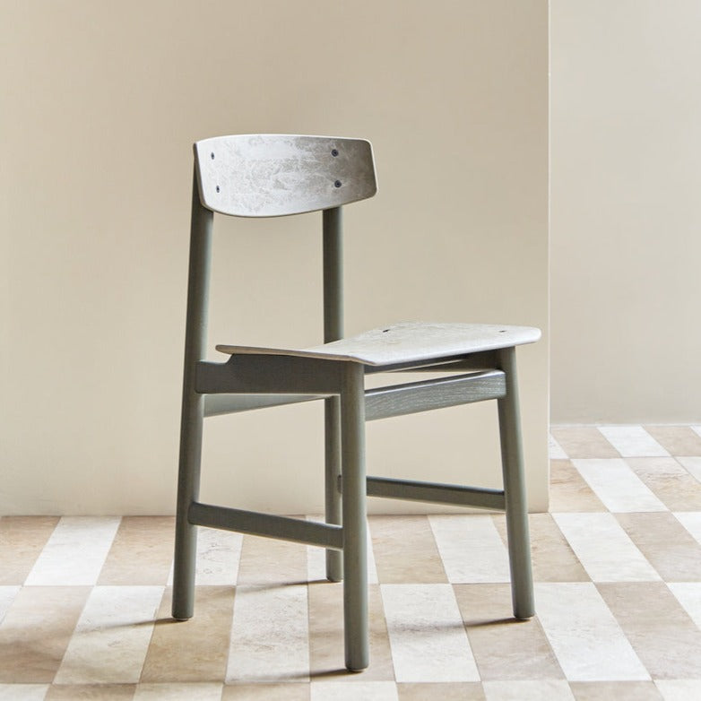 A green Conscious chair made with recycled material, by Mater, in portrait.