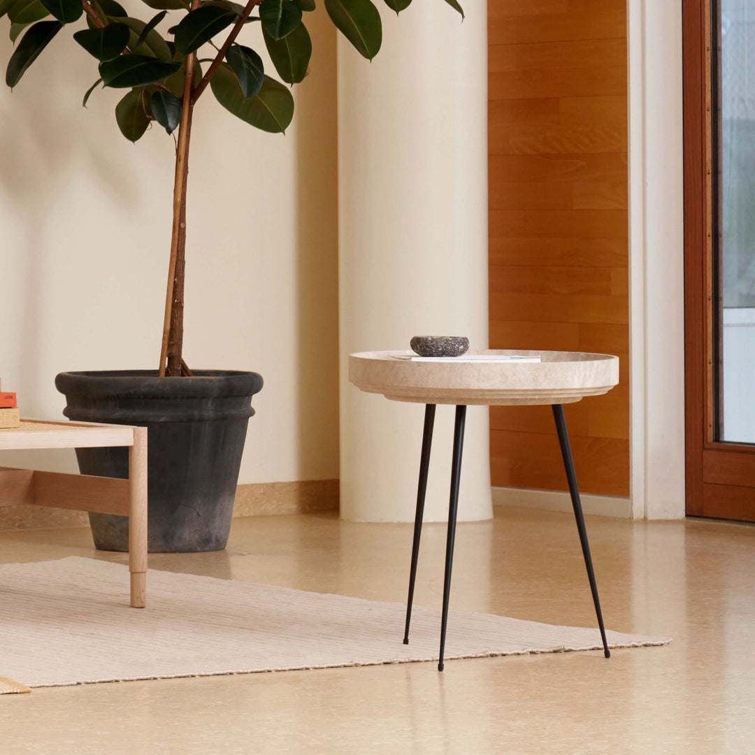 An eco-friendly light Matek bowl table made with recycled material by Mater, in a living room.