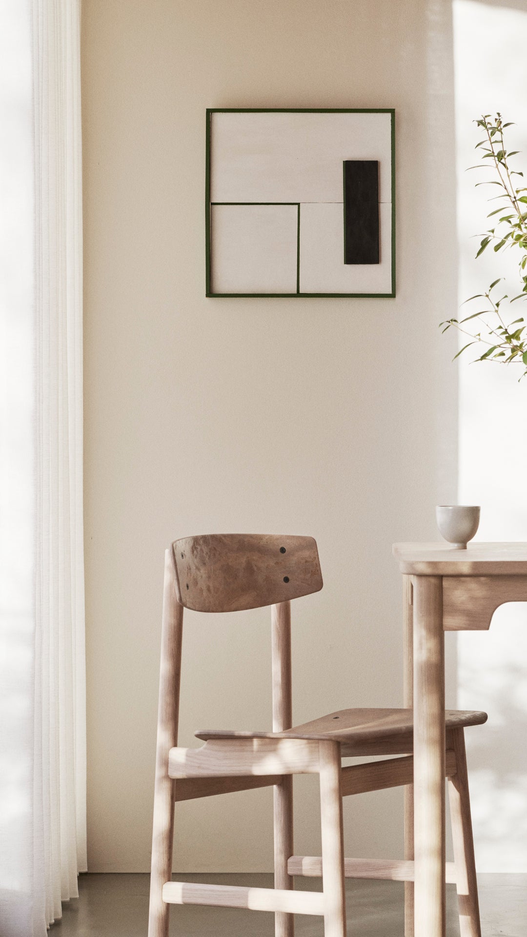 A portrait of a table with light Conscious chairs made with recycled material by Mater, in a living room.