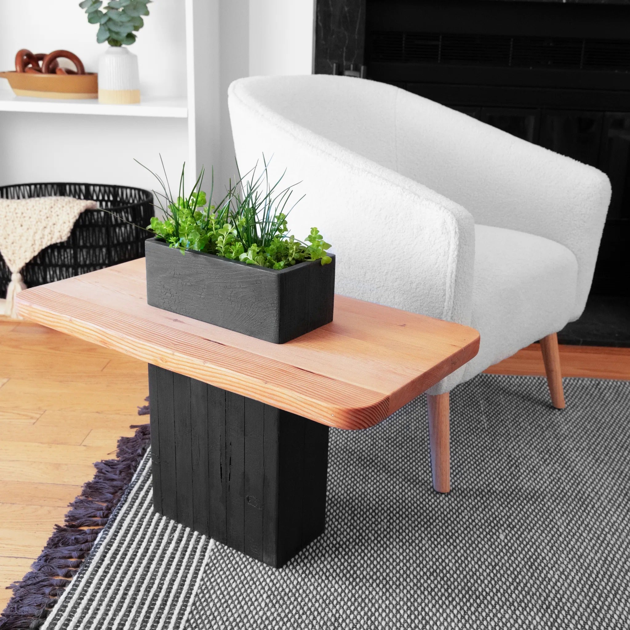 A reclaimed wood VegeTABLE Side Table with Planter by Formr, displayed next to a white plush armchair.