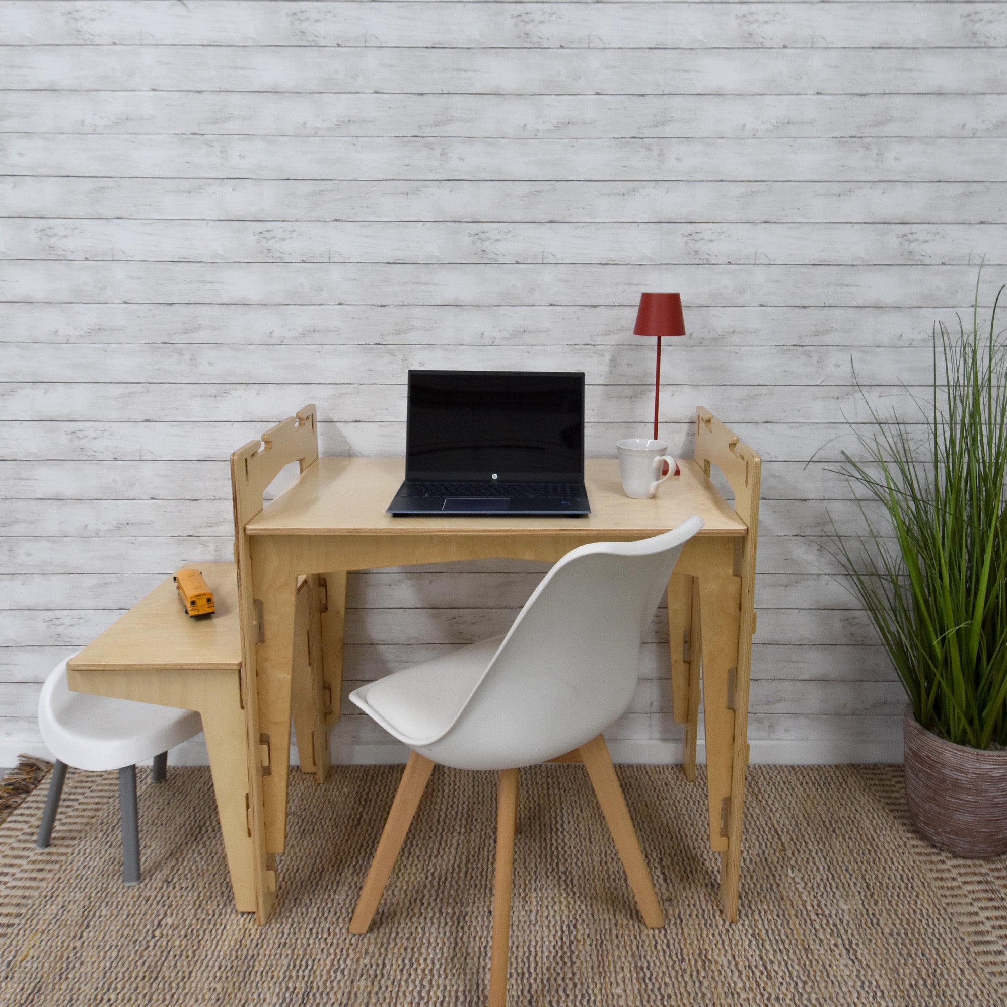 A handcrafted MOD5 Adjustable Modular Desk made of FSC-certified wood by FiVO, with the extension leaf lowered to childrens height.