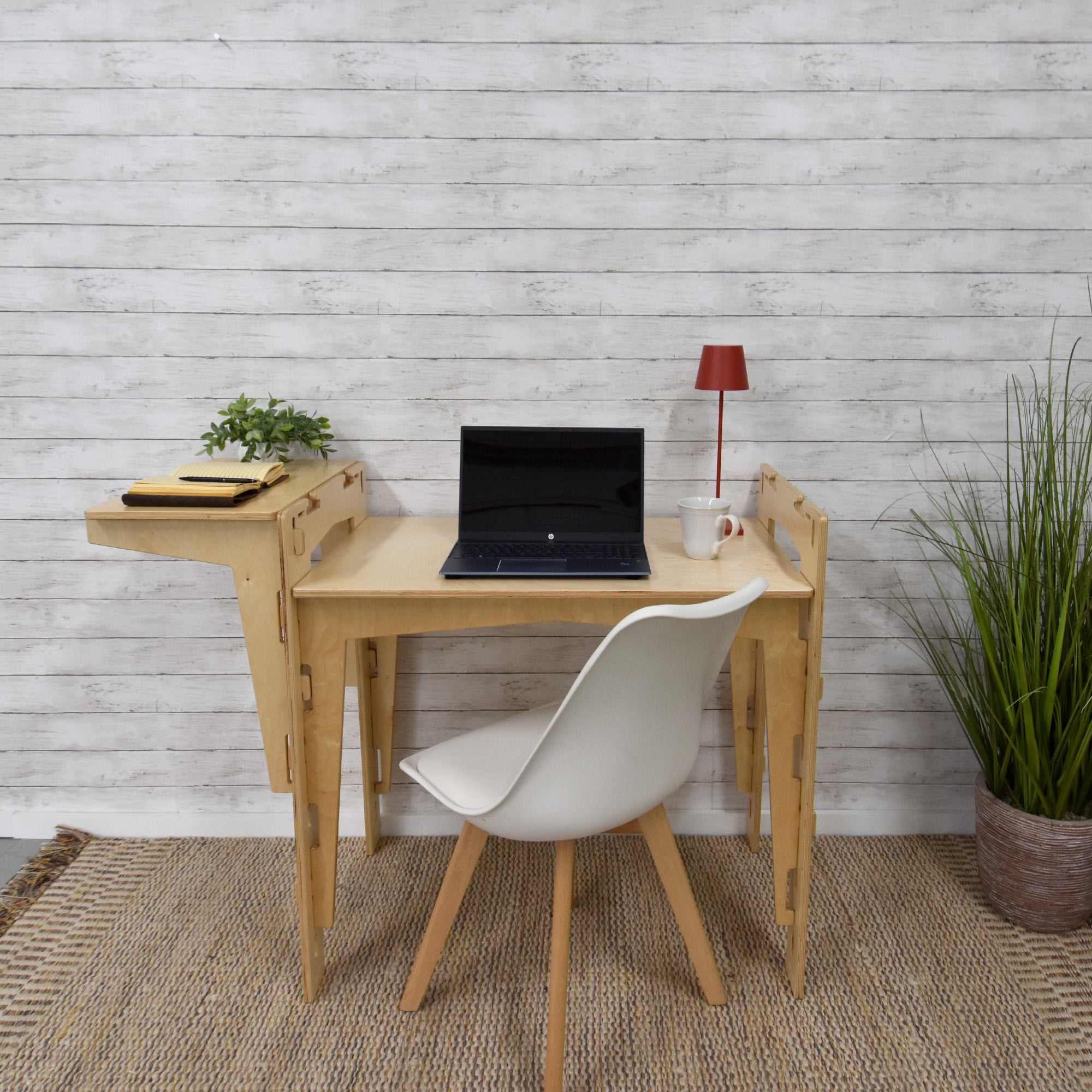 A handcrafted MOD5 Adjustable Modular Desk made of FSC-certified wood by FiVO, with the extension leaf raised higher than the main table.