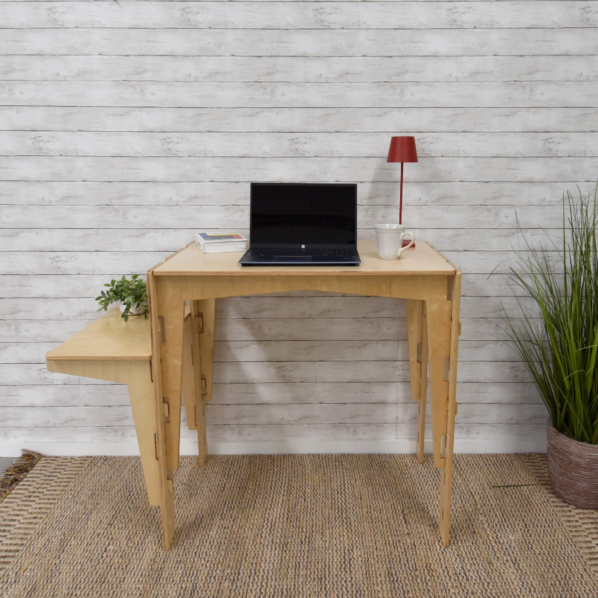 A handcrafted MOD5 Adjustable Modular Desk made of FSC-certified wood by FiVO, with the extension leaf adjusted to be lower than the main table.