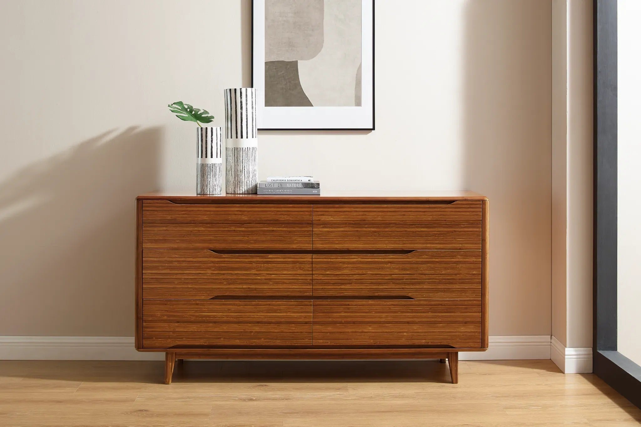 A renewable Currant Bamboo Low Dresser by Greenington, in amber color, placed in a living room.