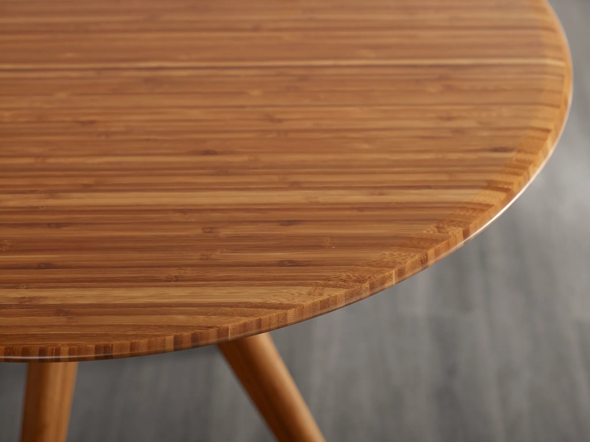 The edge of the round surface of the eco-friendly Sitka Bamboo Dining Table, by Greenington.