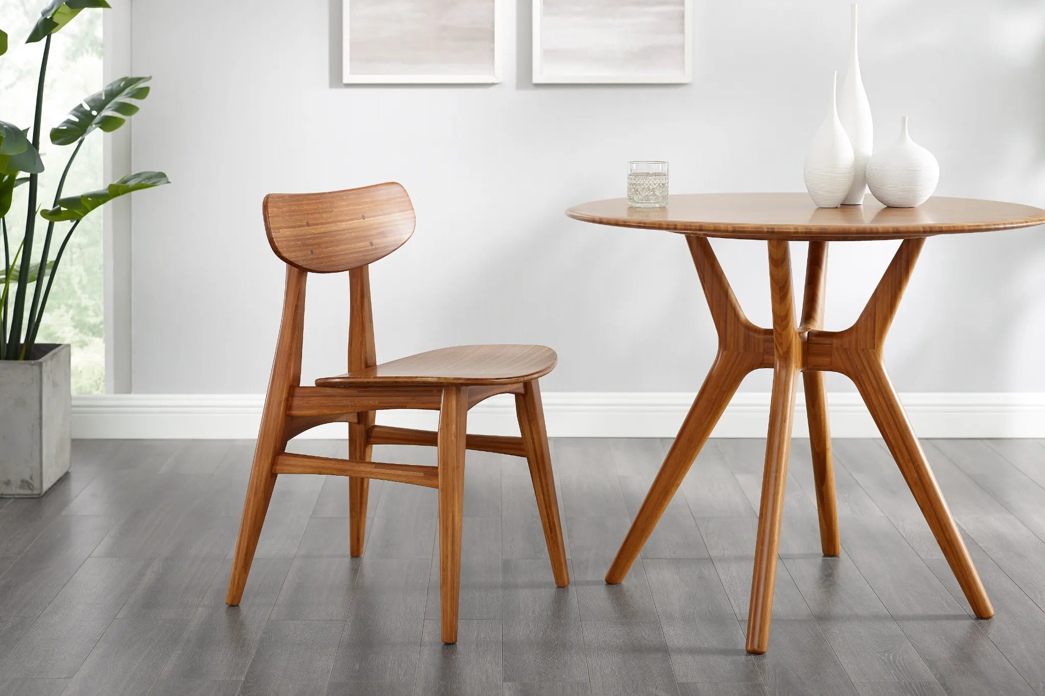 An eco-friendly Sitka Bamboo Dining Table by Greenington, in amber color, together with a bamboo chair in a dining room.