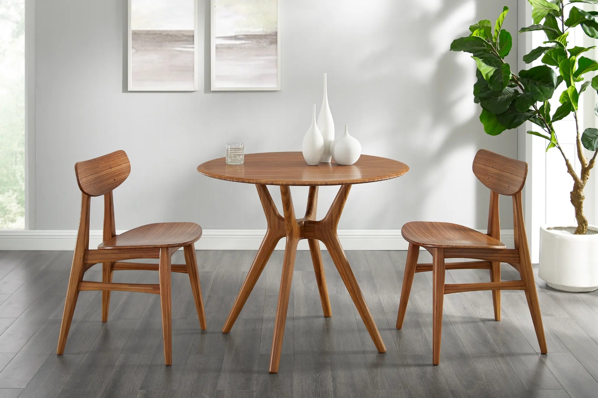 An eco-friendly Sitka Bamboo Dining Table by Greenington, in amber color, together with two bamboo chairs in a dining room.