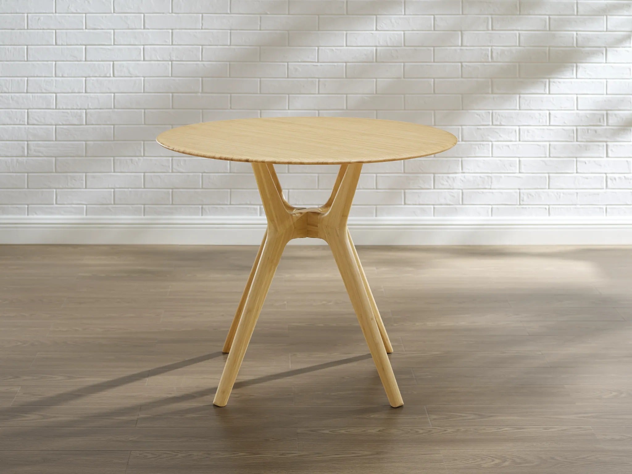 An eco-friendly Sitka Bamboo Dining Table by Greenington in wheat color, placed in a room.