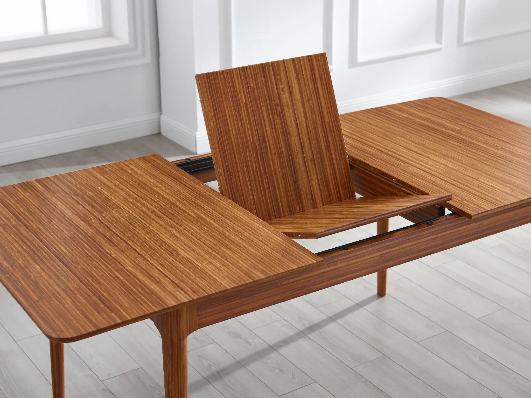 The hidden extension of the sustainable Mija Extendable Dining Table by Greenington, lifted.