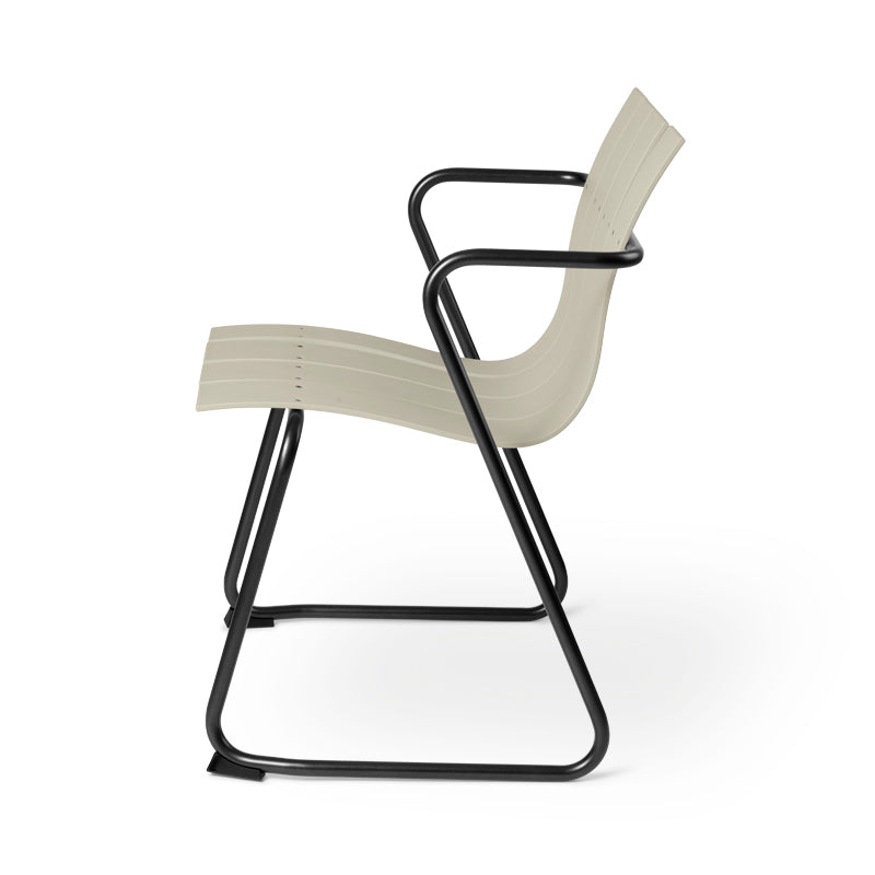 An Ocean Chair by Mater, made of metal and recycled plastic fishing nets, in sand color, side view.