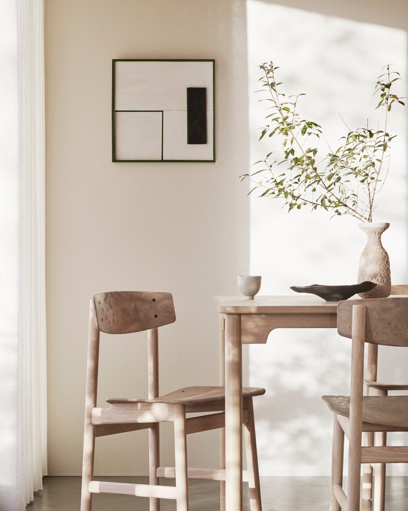 A room with a table and two Conscious chairs made with recycled material by Mater.