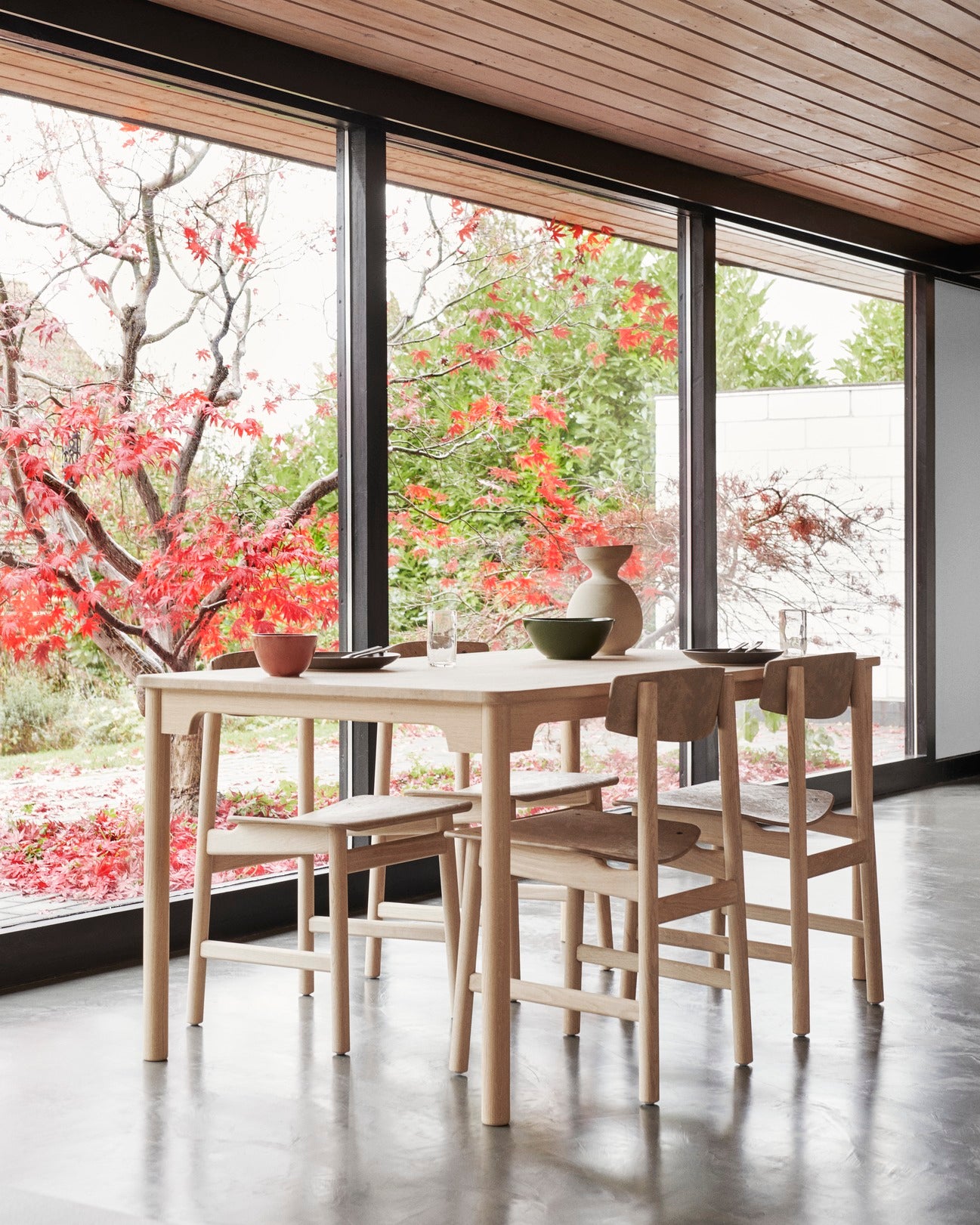 A sustainable dining table with four Conscious chairs made with recycled material by Mater, in a dining room.