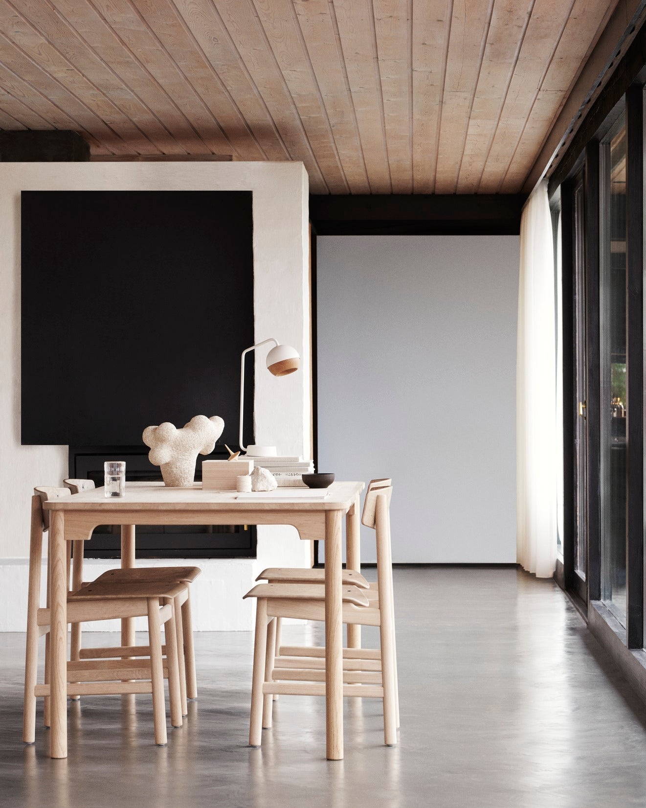 An eco-friendly table with four light Conscious chairs made with recycled material by Mater, in a dining room.