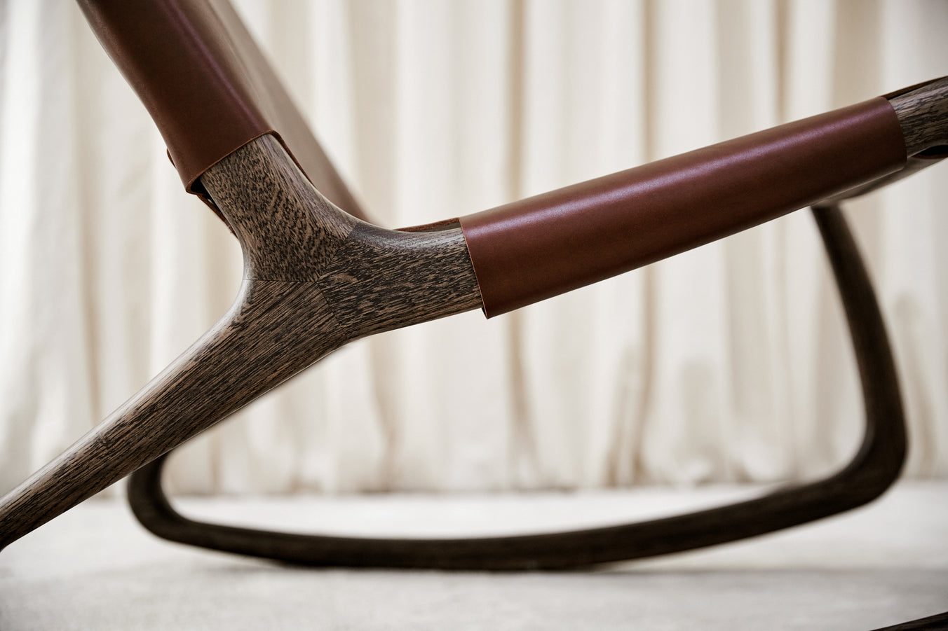 A detail view of a dark brown Modern Rocker Chair made of FSC-certified wood, by Mater.