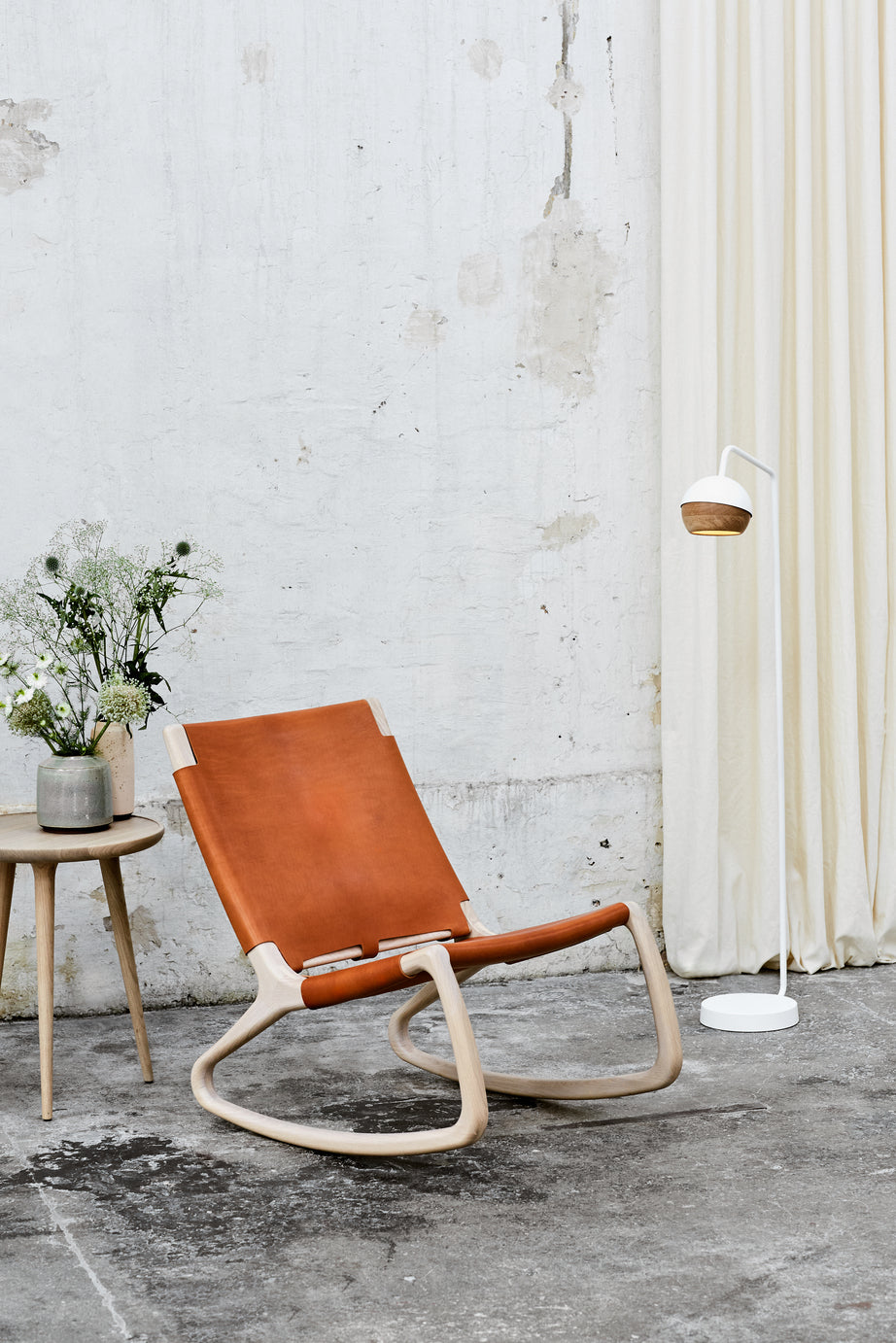 A tan leather Modern Rocker Chair made of FSC-certified wood by Mater, wider view.