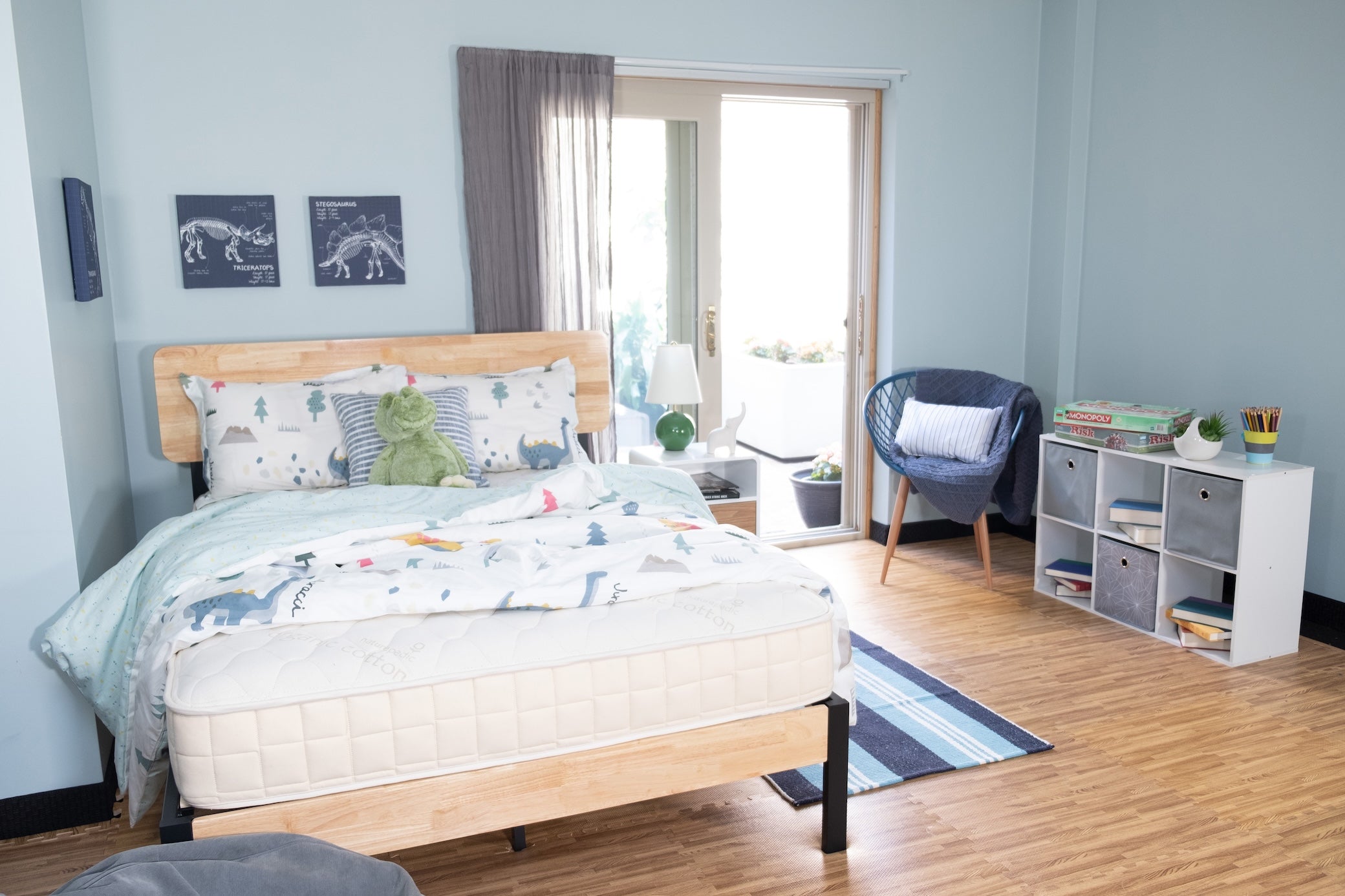 Bedroom with wooden bed, plush toys, and a window with curtains.
