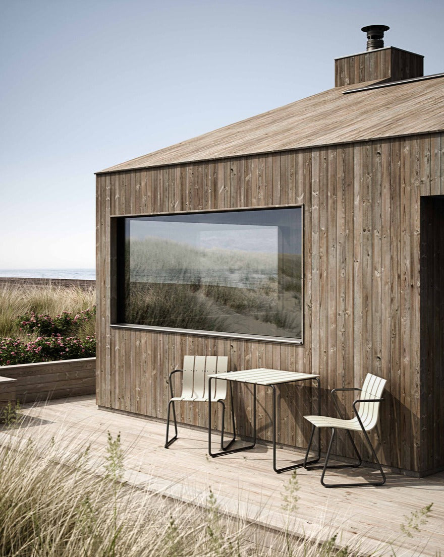 Two Square Ocean Tables made with recycled plastic by Mater, in sand color, shown outdoors with two matching Ocean Chairs.